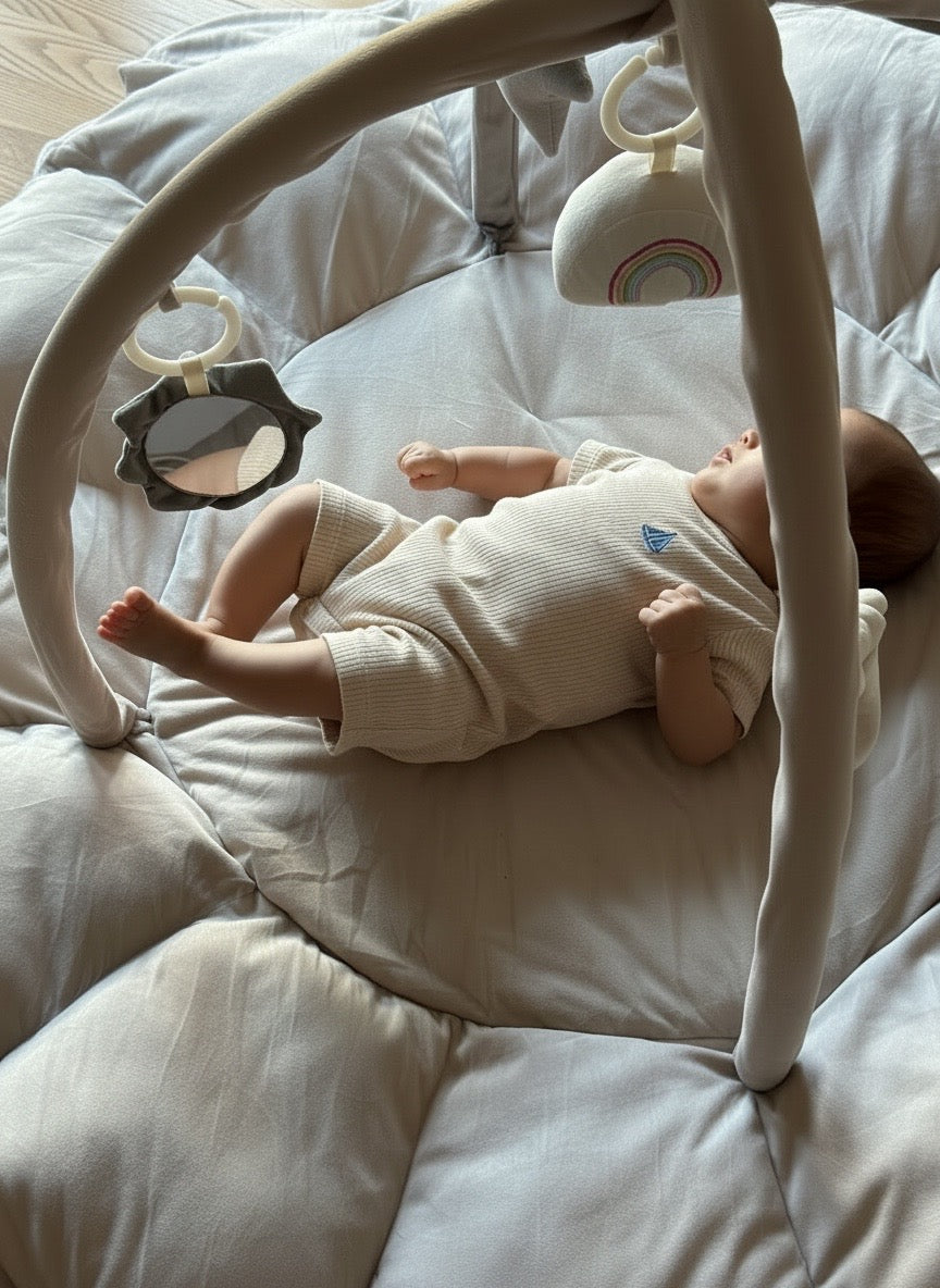 Baby lying on a Lumee Novi play gym