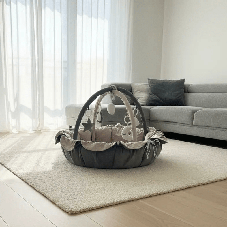 Baby play gym on a rug in a living room with a sofa and curtains.