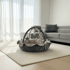 Baby play gym on a rug in a living room with a sofa and curtains.