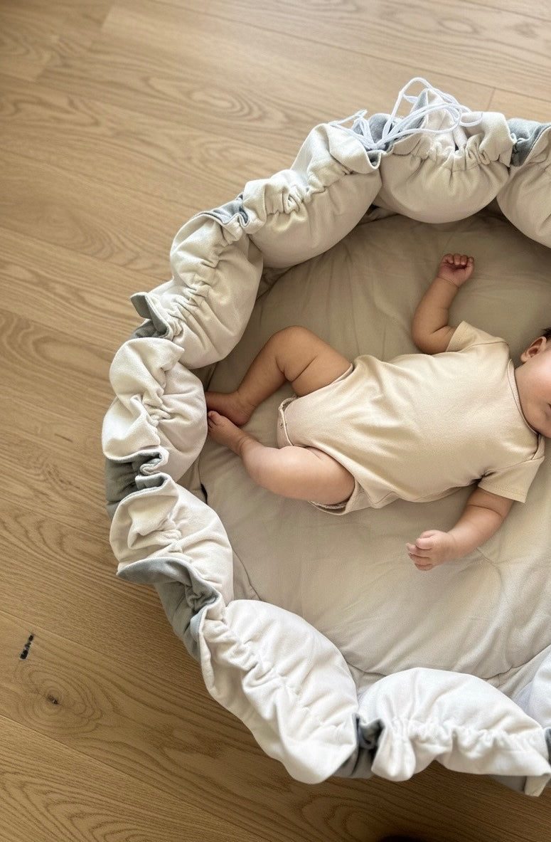 Baby lying on a soft and padded Novi Lumee play mat on